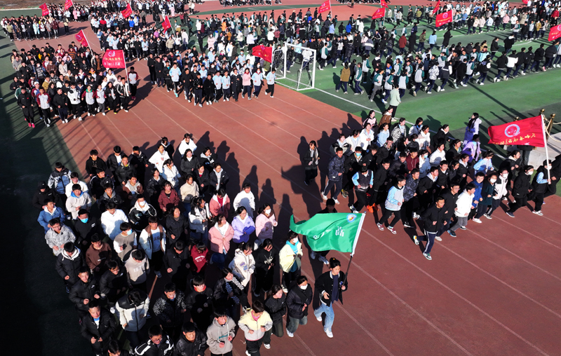 12月25日，来自民和县官亭镇土族中学的学生在民和县城西高级中学的操场上跑操（无人机照片）。新华社记者 王�� 摄